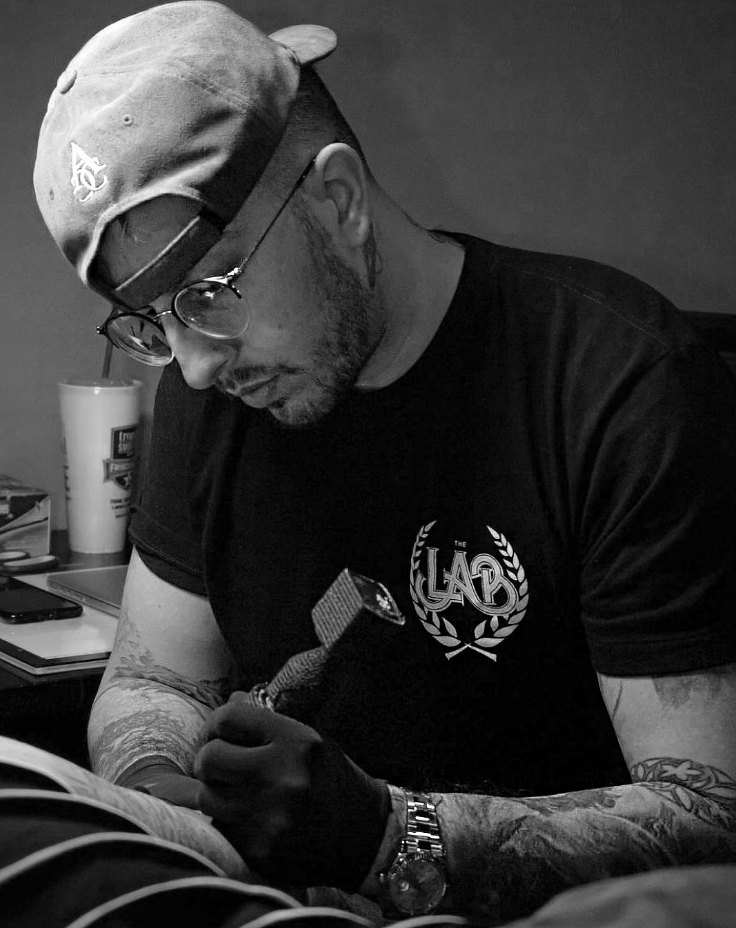 dan price, tattoo artist, tattooing a leg in his studio